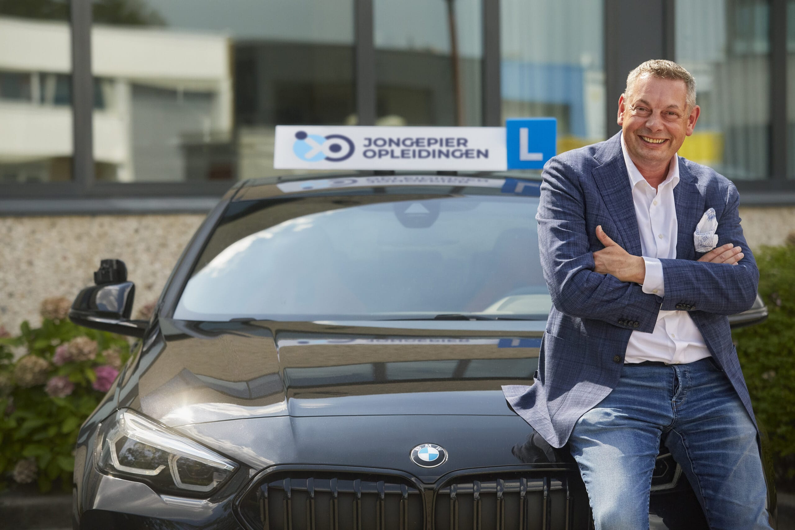Simon Jongepier jr. bij een lesauto van Jongepier Opleidingen